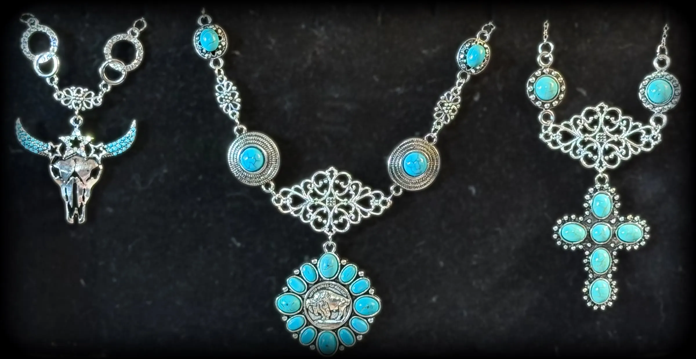 Three statement necklaces: a star longhorn skull on rings, a buffalo-nickel turquoise blossom and a turquoise cross on filigree