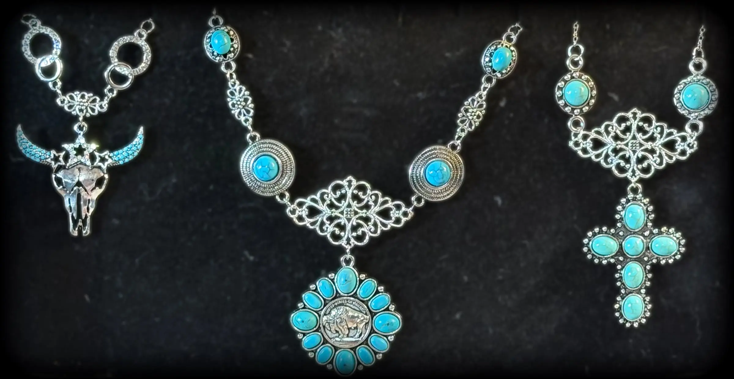 Three statement necklaces: a star longhorn skull on rings, a buffalo-nickel turquoise blossom and a turquoise cross on filigree