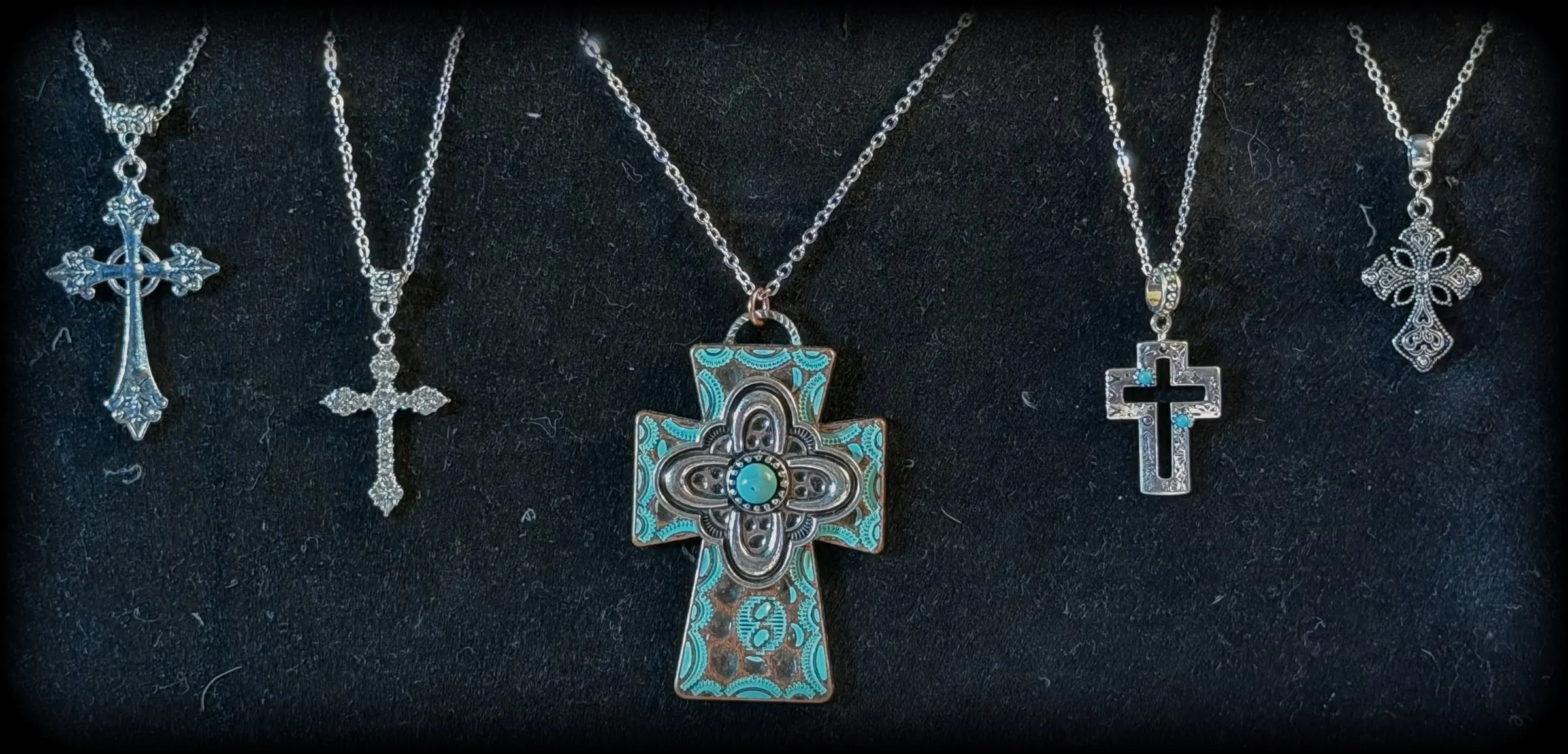 Five cross pendants: a fleur cross, a filigree cross, a large patina turquoise cross, an open turquoise cross and a lace cross
