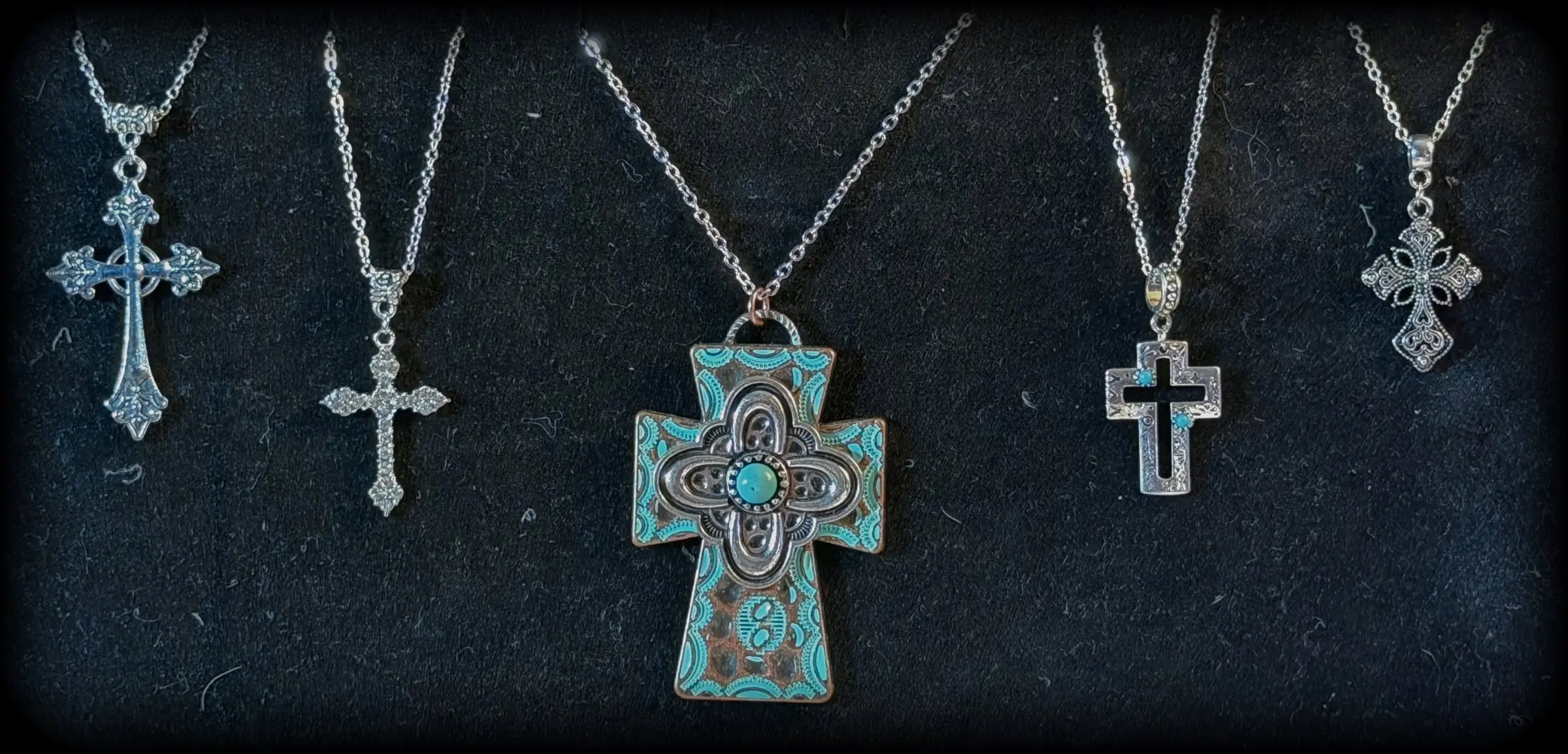 Five cross pendants: a fleur cross, a filigree cross, a large patina turquoise cross, an open turquoise cross and a lace cross