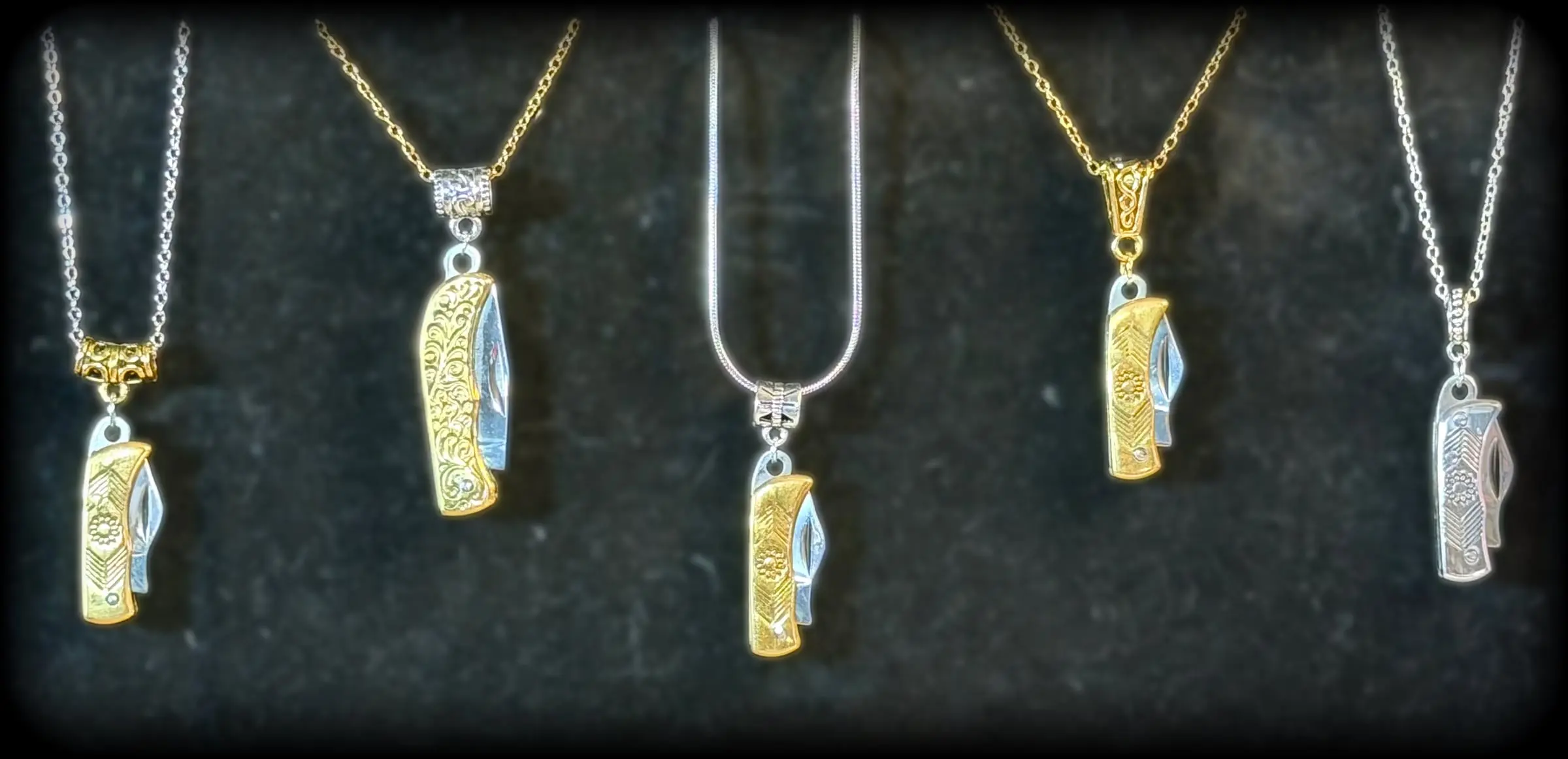 Five mini pocketknife pendants in gold and silver tones