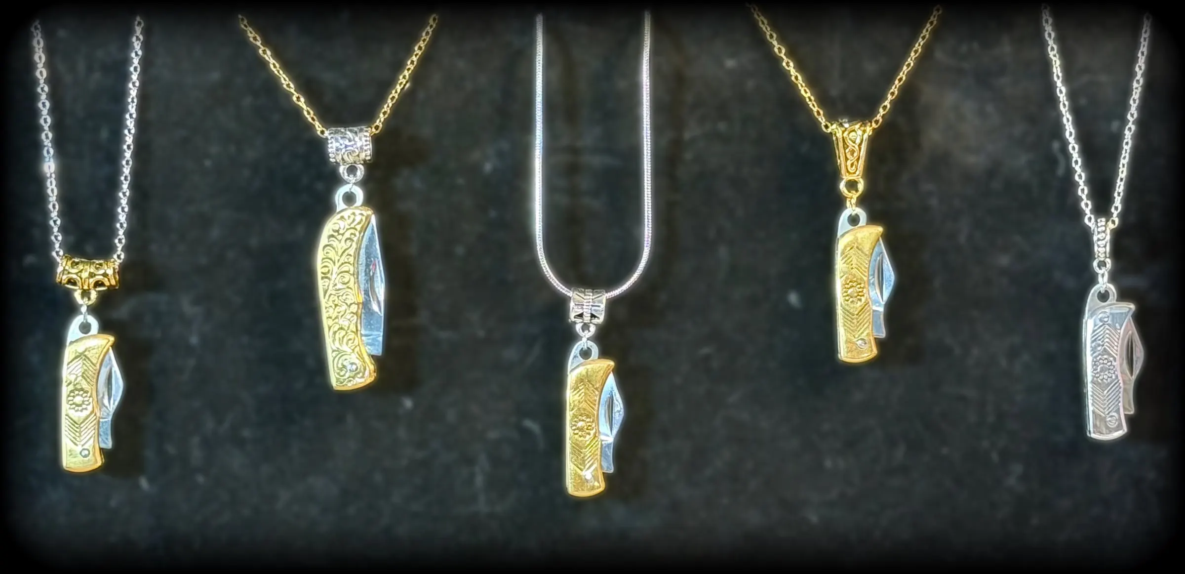 Five mini pocketknife pendants in gold and silver tones