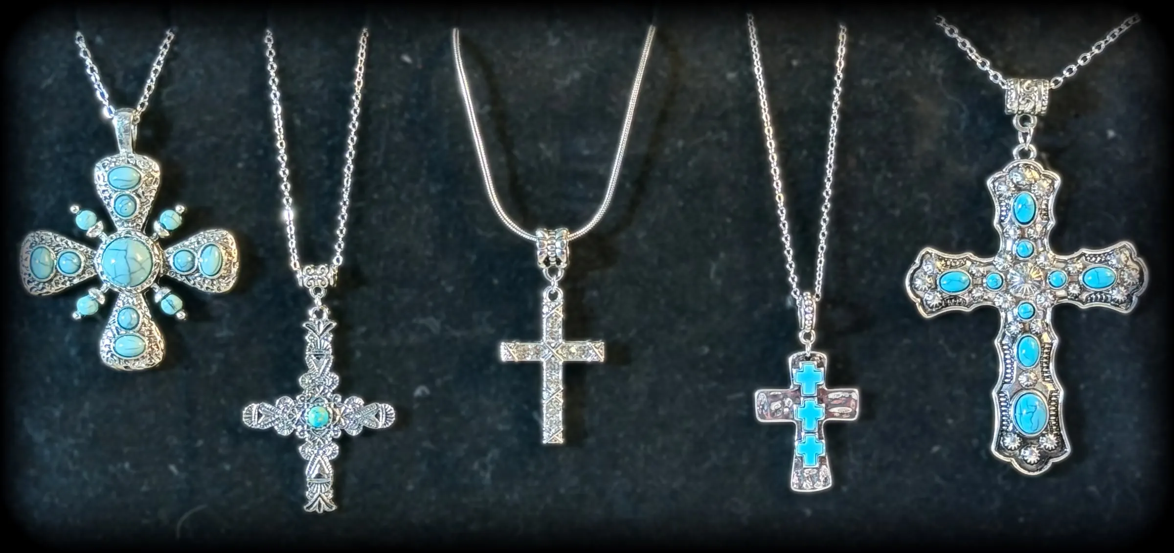 Five turquoise and silver cross pendants, from a Maltese-style cross to a crystal statement cross