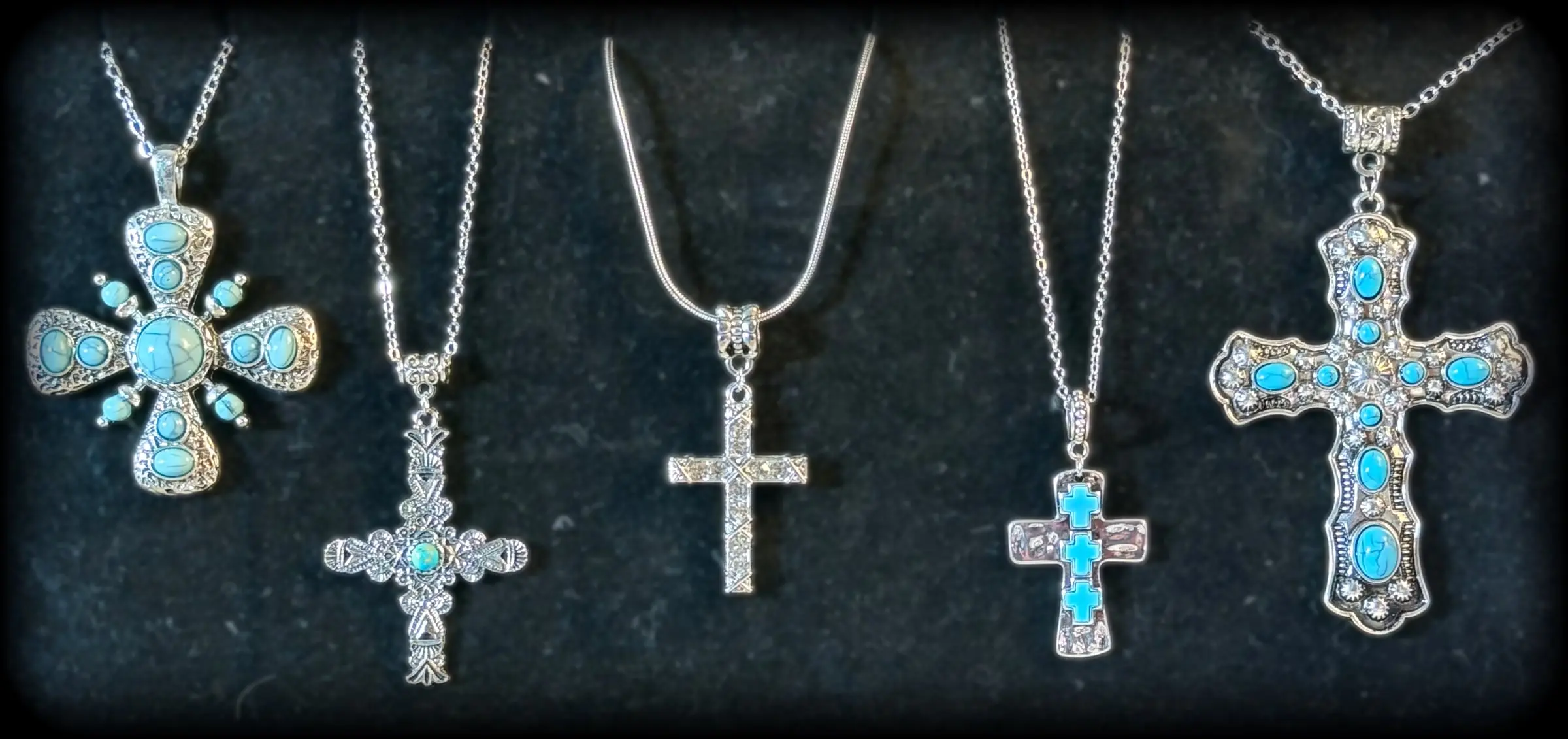 Five turquoise and silver cross pendants, from a Maltese-style cross to a crystal statement cross