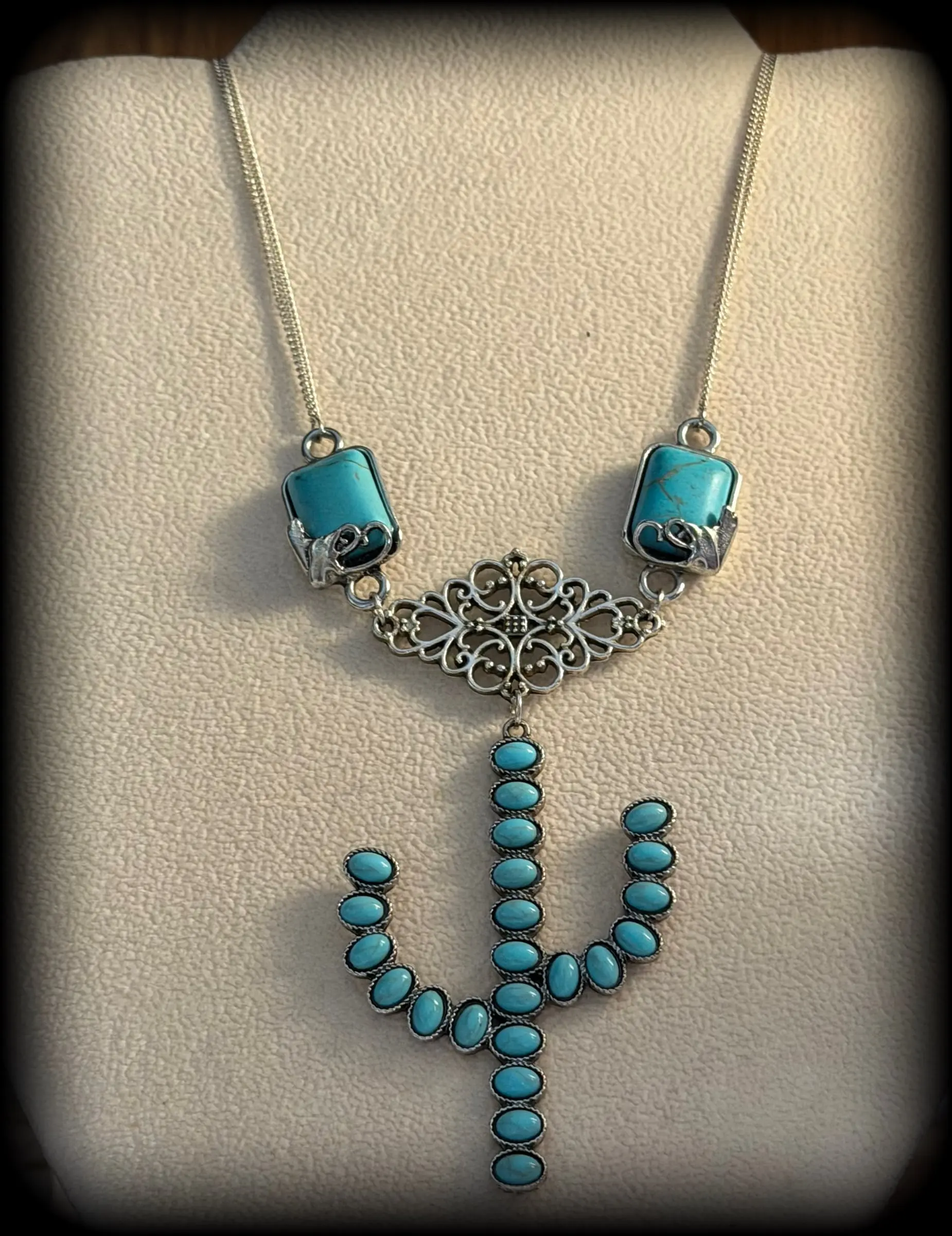 A necklace with turquoise bars, a filigree centerpiece and a saguaro cactus made of turquoise beads